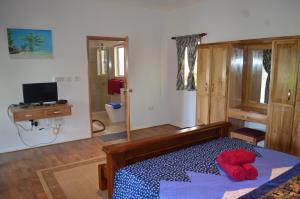 um quarto com uma cama com um bicho de peluche vermelho em Nid'Aigle Lodge em Praslin