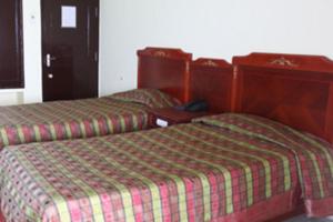two beds sitting next to each other in a room at RNS Guest House in Māvalli
