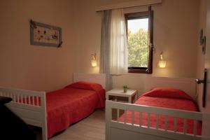 2 łóżka w małym pokoju z oknem w obiekcie Villa Alba Chiara w mieście Uranupoli +37 zdjęć