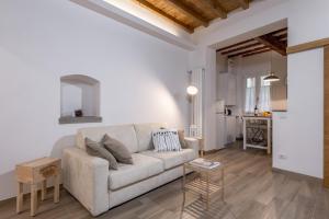 a living room with a white couch and a table at Santa Croce Place by Mmega in Florence