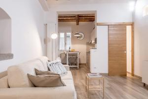 a living room with a white couch and a table at Santa Croce Place by Mmega in Florence +8 photos