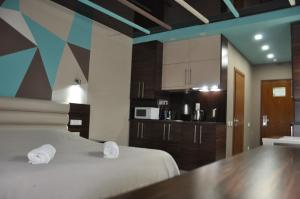 Habitación con cama y cocina en White Sail Apartments, en Batumi