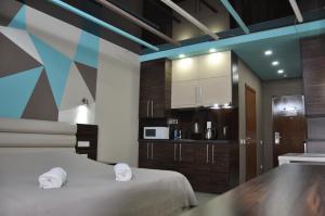 a room with a bed and a kitchen with a microwave at White Sail Apartments in Batumi