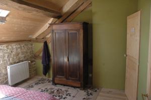 ein Schlafzimmer mit einem Holzschrank in der Ecke eines Zimmers in der Unterkunft Hello velo in Tintury