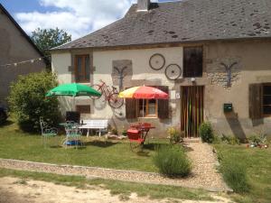 a house with two umbrellas and a table and chairs at Hello velo in Tintury