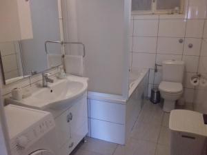 La salle de bains blanche est pourvue d'un lavabo et de toilettes. dans l'établissement Jordan, à Kaštela