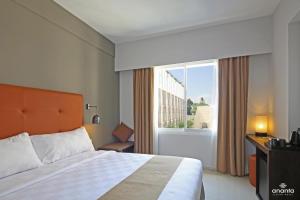 Un pat sau paturi într-o cameră la Ananta Legian Hotel