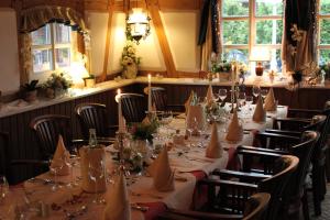 un comedor con una mesa larga y sillas en Stelinger Hof Hotel Münkel en Hannover