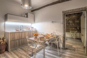 jadalnia ze stołem i krzesłami oraz kuchnia w obiekcie iRoom Civita w mieście Bagnoregio