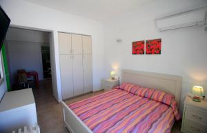 a small bedroom with a bed and a dresser at Kastellos Apartments Sikinos in Alopronia