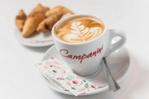 a cup of coffee and a plate of pastries at Hostal Brisa Marina in Port d'Alcudia