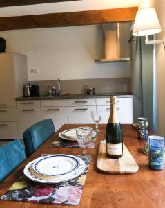 uma garrafa de vinho sentada numa mesa de madeira em Apple Tree Cottage - discover this charming home at beautiful canal in our idyllic garden em Gouda