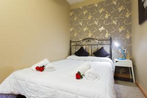 タラゴナにあるFont 1 Circo Romanoのベッドルーム1室(赤いバラの白いベッド1台付)
