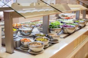 a buffet line with many different types of food at Hipotels Barrosa Garden in Chiclana de la Frontera