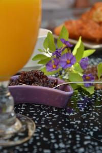 a purple plate of food with flowers and a drink at Posada Chloe Santiago in Santiago de la Ribera