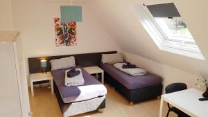 Kleines Dachzimmer mit 2 Betten und einem Tisch in der Unterkunft Ferienwohnung Fulda in Fulda