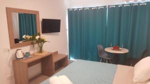 a room with a bed and a table and a mirror at Manoli Apartments in Ayia Napa