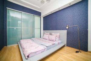 a bedroom with a bed and a blue wall at Vip Arenda Minsk in Minsk