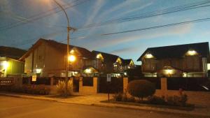 una fila de casas por la noche con luces en Patagonia Apart en Esquel