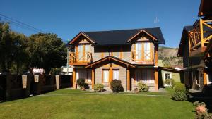 una casa con techo negro y patio en Patagonia Apart en Esquel