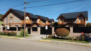 Une rangée de maisons sur le côté d'une rue dans l'établissement Patagonia Apart, à Esquel