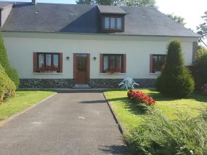 a white house with a red door and a driveway at Gite a la ferme in Villeroy