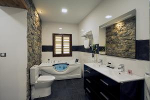 Un baño con inodoro, lavabo y bañera. en Urdaibai Etxea, en Ea