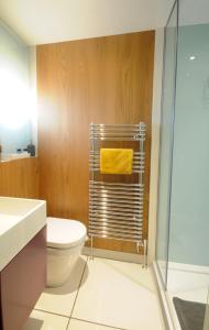 a bathroom with a toilet and a yellow towel at Mulberry cottage in Cheltenham +35 photos