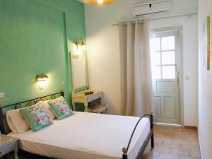 a bedroom with a white bed and a window at Orion Apartments in Malia