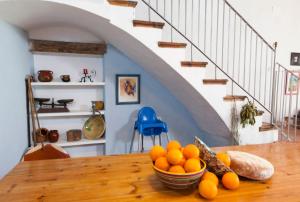 eine Schüssel Orangen auf einem Holztisch mit einer Treppe in der Unterkunft Ca La Partida in San Rafael del Río
