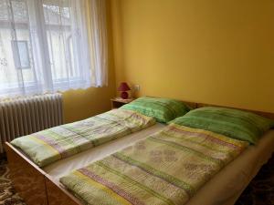 two beds sitting next to each other in a bedroom at Napsugár Vendégház in Kehidakustány