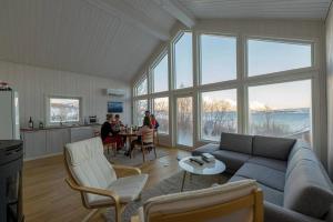 a living room with a couch and people sitting at a table at Aurora View Cabin in Lyngseidet