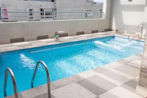 a large pool with blue water in a building at Full Moneda 909 in Santiago
