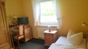 - une chambre avec un lit, un bureau et une fenêtre dans l'établissement Landhotel Weingut Schulze, à Freyburg