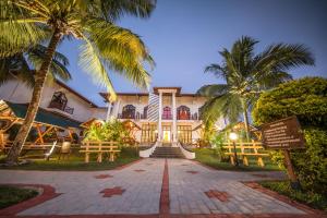 a house with palm trees in front of it at Hotel Yapahuwa Paradise in Yapahuwa