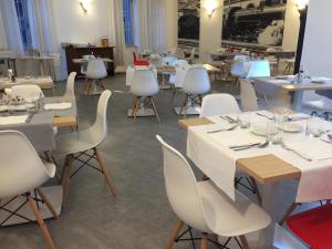 a dining room with white tables and white chairs at Hotel Internazionale Luino in Luino