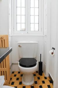 a bathroom with a toilet with a black lid at 3 Marias Residence in Viana do Castelo