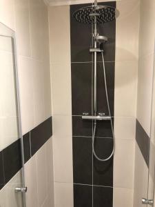 a bathroom with a shower with black and white tiles at T2 centre-ville place d'Armes Clim-Wifi in Toulon