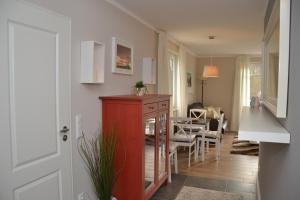 ein Wohnzimmer mit einem roten Schrank und einem Esszimmer in der Unterkunft Villa Ilse in Heringsdorf
