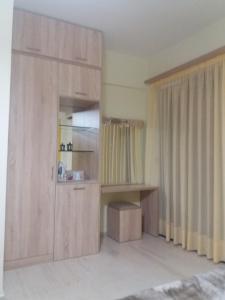 a room with a large wooden cabinet with a shelf and curtains at Nikos & Anna Rooms in Rodakino +27 photos