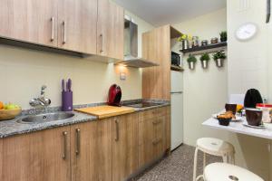 una cocina con armarios de madera y fregadero en Roger Balcon Mediterraneo Tarragona en Tarragona