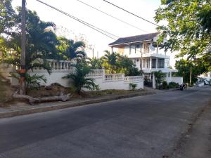 una calle con una valla blanca y una casa en Marysol Lodging Hostel & Camping, en San Andrés