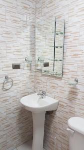 Cabañas Rayen في Río Bueno: حمام مع حوض ومرآة ومرحاض