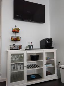 a white cabinet with a flat screen tv on a wall at Albergue Xabarín in Abadín