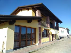 a house with glass doors and a balcony at B&B Da Levi Piana Del Sole in Rivalta Bormida