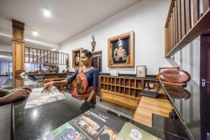 a woman standing at a counter in a shop at Hotel Yapahuwa Paradise in Yapahuwa
