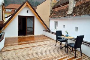 a balcony with a table and chairs on a wooden deck at Arce Boutique in Braşov