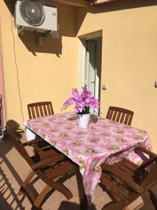 una mesa con un mantel con flores púrpuras. en B&B Iris, en Taormina