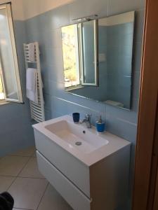 Un baño con un lavabo blanco y un espejo. en B&B Iris, en Taormina 27 fotos más