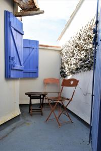 dwa krzesła, stół i niebieskie drzwi w obiekcie Le Fangassier w Saintes-Maries-de-la-Mer